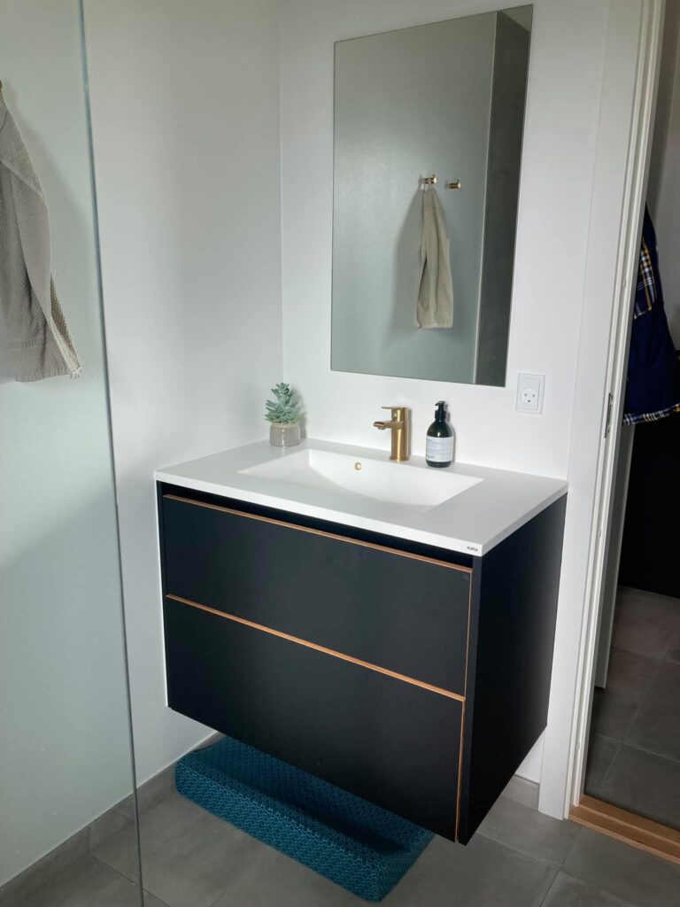 Moderne badeværelse med sort vaskeskab og spejl