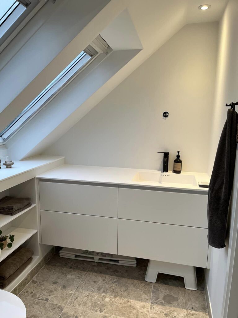 Moderne badeværelse med vask under skråvindue