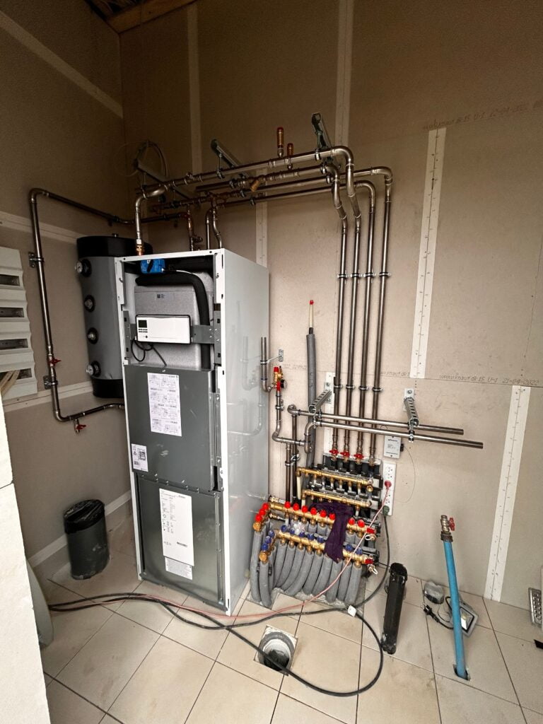Moderne varmepumpeinstallation i teknikrum med rør og ventiler