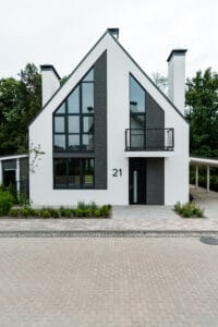 Moderne hvidt hus med store vinduer og altan