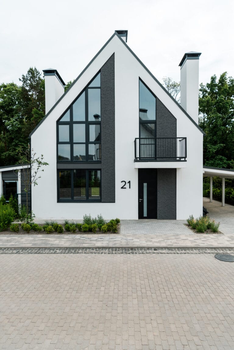 Moderne hvidt hus med store vinduer og altan